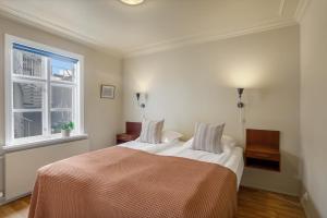 a bedroom with a bed and a window at Grettir Guesthouse Downtown Charm in Reykjavík
