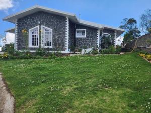 a house with a green lawn in front of it at Hideout by Cloudwalks in Kodaikānāl