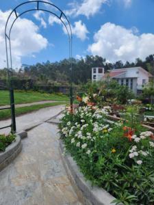 a garden with flowers on a walkway at Hideout by Cloudwalks in Kodaikānāl +8 photos