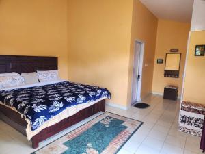 a bedroom with a bed with a blue and white comforter at Hideout by Cloudwalks in Kodaikānāl