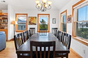 a dining room with a large wooden table and chairs at 6155 - Designed to Please in Nags Head +90 photos