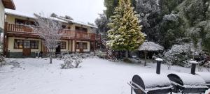 a snow covered yard in front of a house at De las Rosas Bariloche in San Carlos de Bariloche