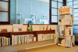 a library with wooden shelves filled with books at ふもとの山小屋 ネイバーズ Neighbors - Alpine Base Inn in Matsumoto