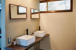 a bathroom with two sinks on a wooden counter at ふもとの山小屋 ネイバーズ Neighbors - Alpine Base Inn in Matsumoto