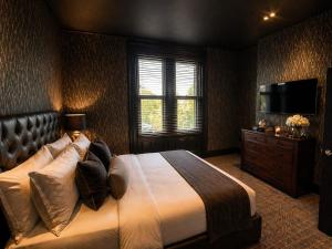 a bedroom with a large bed and a flat screen tv at Hotel Eighteen92 in Liverpool