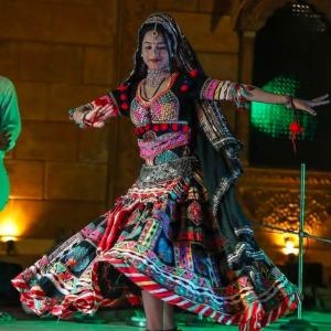 a woman in a dress dancing on a stage at Desert Story Night Camp in Jaisalmer
