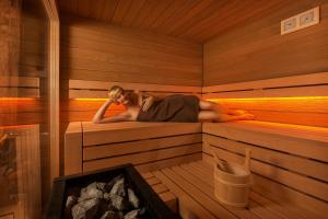 a man is laying in a sauna at Sera Lodge in Grächen