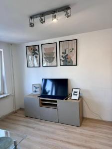 a living room with a flat screen tv on a cabinet at Metro Central 3 Rooms Apartment in Warsaw