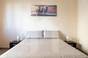 a bedroom with a bed with a painting on the wall at Homiday - Appartamento Via Roma, 32 in Pineto
