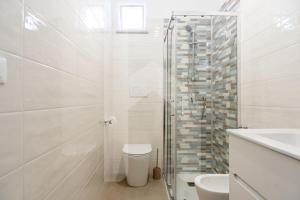 a bathroom with a shower and a toilet and a sink at Homiday - Appartamento Via Roma, 32 in Pineto +14 photos