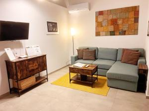 a living room with a couch and a tv at Basso 61 Urban Oasis with Private Mini Pool & Courtyard - Families & Groups in Palermo