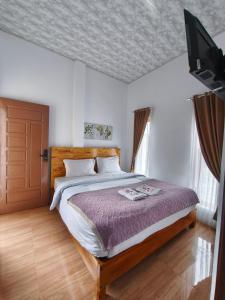a bedroom with a bed and a flat screen tv at M2 Homestay Berastagi in Berastagi +243 photos