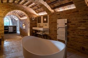 a bathroom with a bath tub in a brick wall at Stelle di Monte in Montepulciano