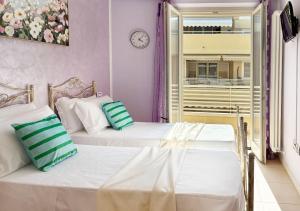 two beds in a room with a clock on the wall at Holihome Hill View in Tortoreto Lido