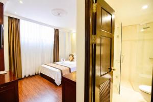 a bedroom with a bed and a bathroom with a shower at Orange City Center Hotel Da Nang - Near Han Market & Dragon Brigde in Danang