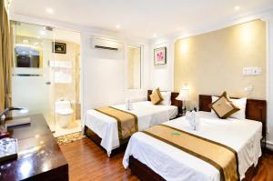 a hotel room with two beds and a bathroom at Orange City Center Hotel Da Nang - Near Han Market & Dragon Brigde in Danang