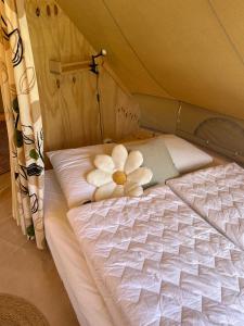 a teddy bear sitting on a bed in a tent at Belltent 't Bievink - buitengewoon overnachten in Westendorp