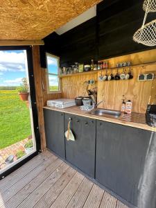 a kitchen with a sink and a counter with a window at Belltent 't Bievink - buitengewoon overnachten in Westendorp