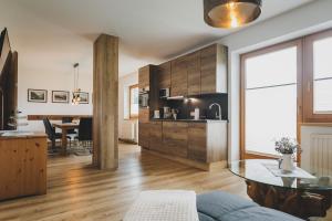 a living room with a table and a kitchen at Apartpension Oberhauser in Kaprun