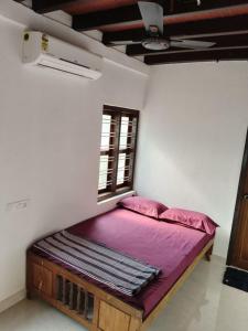 a small bed in a room with a window at beach homestay sea view in Kannur