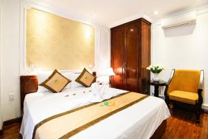 a bedroom with a white bed and a yellow chair at Orange City Center Hotel Da Nang - Near Han Market & Dragon Brigde in Danang