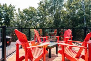 a group of red chairs and a table on a deck at Le Yéti de Tremblant in La Conception