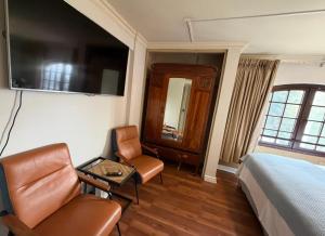 a hotel room with a bed and a chair at Aragonés departamentos in Temuco