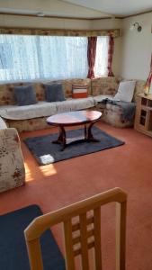 a living room with a coffee table and a couch at The discovery whitehouse towyn in Kinmel Bay
