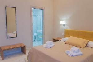 a bedroom with a bed with two towels at Le Suite in Crotone