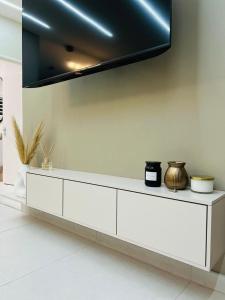 a white cabinet with a tv on a wall at Casa Bonheur in Windhoek