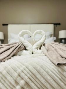 two towels shaped like hearts are on a bed at Casa Bonheur in Windhoek +16 photos