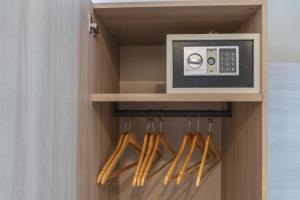 a closet with a microwave and wooden hangers at Le Suite in Crotone
