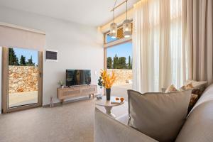 a living room with a couch and a tv at Veragi Boutique Villas in Lefkada