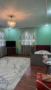 a living room with a bed and a chandelier at Aruzhan Hostel in Shymkent +26 photos