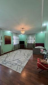 a living room with a large rug on the floor at Aruzhan Hostel in Shymkent