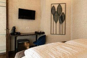 a bedroom with a bed and a desk and a television at Domus Mea Suites in Costermano