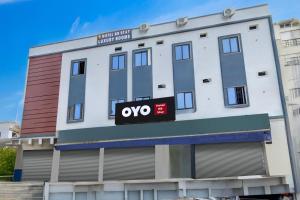 a white building with a qo sign on it at Hotel O RB STAY in Haidar Sāhibgūda +18 photos