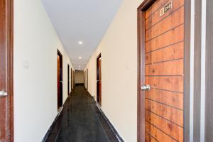 an empty corridor with a wooden door in a house at Hotel O RB STAY in Haidar Sāhibgūda