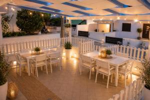 a restaurant with white tables and chairs and lights at Poésia in San Foca