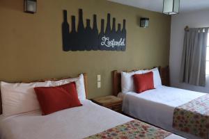 a hotel room with two beds with red pillows at Hotel Casa de Vino in Tequisquiapan +32 photos