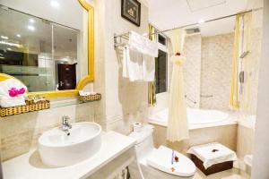 a bathroom with a sink and a toilet and a tub at Orange City Center Hotel Da Nang - Near Han Market & Dragon Brigde in Danang
