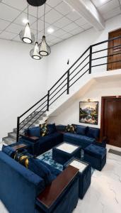 a living room with blue couches and a staircase at Thambara Resort in Polonnaruwa