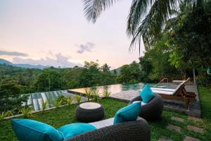 a backyard with a pool and chairs and a tub at Kandy Neela Weralu in Haragama