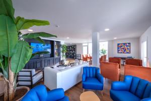 a living room with a white couch and blue chairs at H10 Taburiente Playa in Breña Baja
