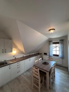 a kitchen with a table and chairs in a room at Penzion Villa Alena in Velké Bílovice