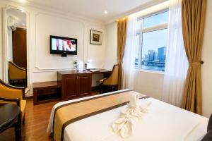 a hotel room with a bed and a desk and a window at Orange City Center Hotel Da Nang - Near Han Market & Dragon Brigde in Danang +17 photos