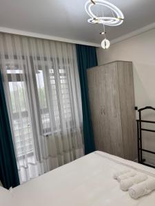 a bedroom with a bed with two towels on it at ЖК Сити Парк in Osh