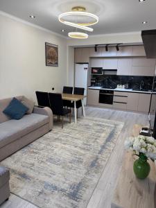 a living room with a couch and a table at ЖК Сити Парк in Osh