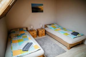 two twin beds in a small room with at Pajtás Vendégház in Örvényes