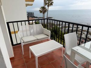 a balcony with a chair and table and the ocean at Balcon Del Mar Primera Linea de Playa in La Cala de Mijas